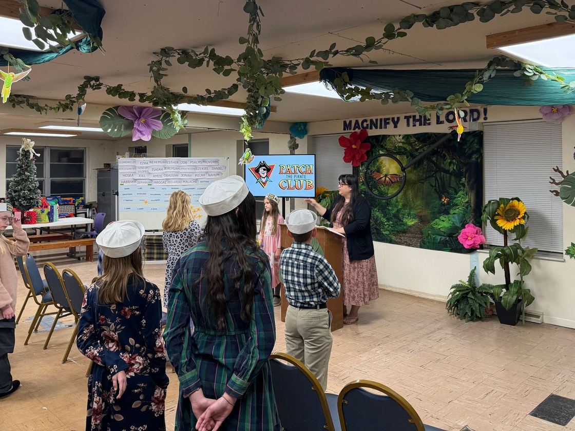 Children in sailor hats performing in a decorated classroom